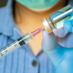 Healthcare professional preparing a syringe from a vial