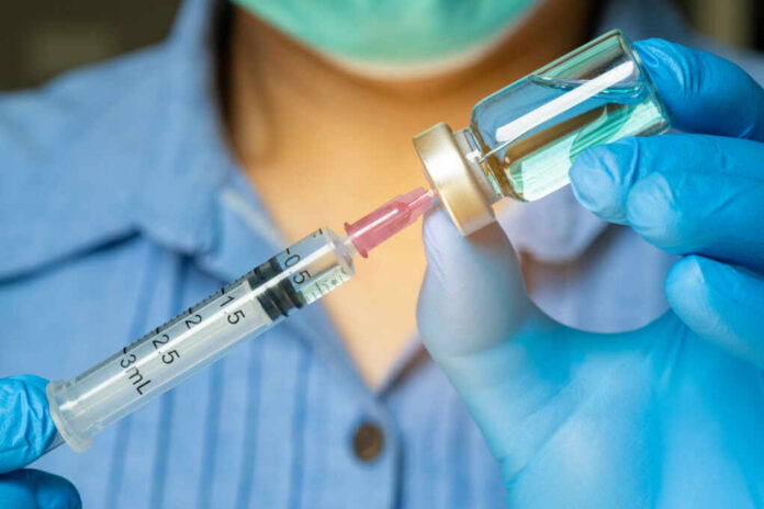 Healthcare professional preparing a syringe from a vial