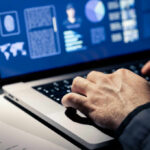 Heat Vs Cold: The Sauna Science Showdown Close-up of hands typing on a laptop with data visualizations on the screen