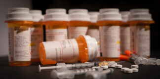 Various prescription medication bottles and syringes on a table