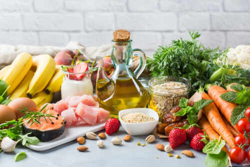 shutterstock_1532929409 (1).jpg A variety of fresh foods including fruits, vegetables, and oils arranged on a table