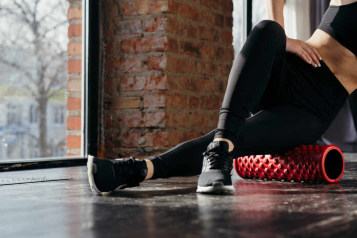 shutterstock_1686887452.jpg Person using a foam roller for stretching in a fitness studio