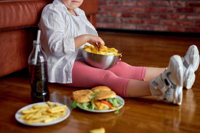 Child sitting on the floor enjoying snacks from a bowl