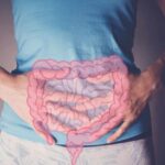 Menopause’s Hidden Gut Rewire Exposed Person holding their stomach with a graphic of intestines overlayed