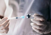 A healthcare professional preparing a syringe from a vial