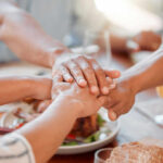Molecular Aging Slowed by Surprising Daily Habit Several hands stacked together over a plate of food, symbolizing unity and support