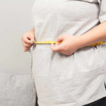 Mayo Clinic Unveils Surprising Menopause Weight-Loss Trick Person measuring their waist with a tape measure