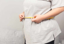 Mayo Clinic Unveils Surprising Menopause Weight-Loss Trick Person measuring their waist with a tape measure