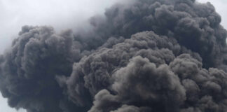 Thick dark smoke billowing into the sky