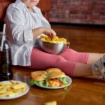 Snack Foods: The Silent Intestinal Threat Child sitting on the floor enjoying snacks from a bowl