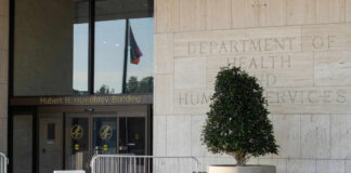 Entrance of the Hubert H. Humphrey Building with a decorative plant and a flag visible