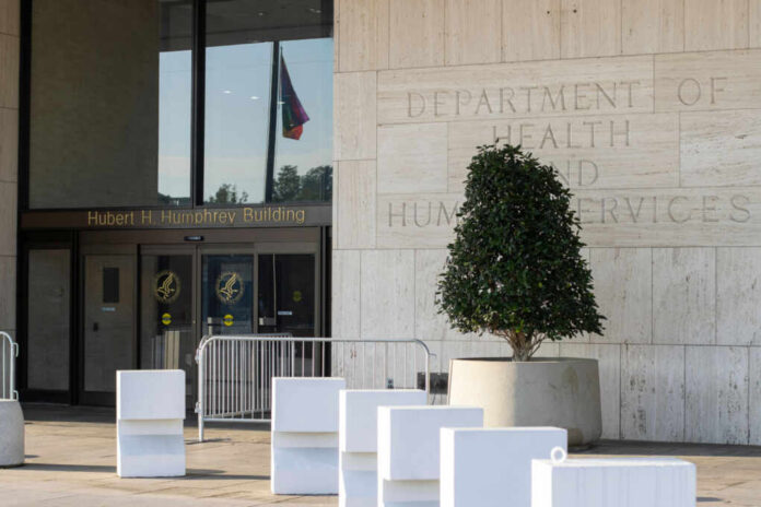 shutterstock_2185666809 Entrance of the Hubert H. Humphrey Building with a decorative plant and a flag visible