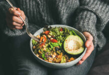 Diet Habit Tied To Depression Spike A person holding a bowl of colorful salad with avocado and greens