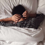 Sleep Myths CRUMBLE — The 7–9 Trap Child lying in bed with hands over ears