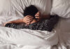 Nightly Sleep Combo Damages Your Heart Child lying in bed with hands over ears