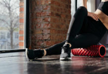 Yoga’s Surprising Role In Stroke Recovery Person using a foam roller for stretching in a fitness studio