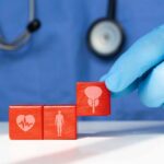Liver Care: BEST Foods to Clean Out Your Liver A doctor's gloved hand placing red blocks with health symbols on a table