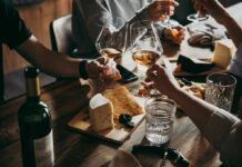 How Moderate Drinking Tricks Your Brain Hands toasting wine glasses over a cheese board