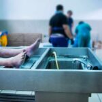 cadaver on stainless autopsy table in clinical room