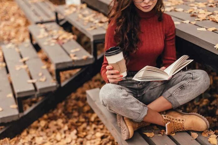shutterstock_1801209442 Woman reading a book on outdoor bleachers