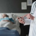 Silent Hunch Tied To Early Death Doctor using tablet beside hospital patient