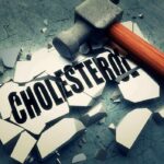 Sledgehammer smashing a tile labeled cholesterol