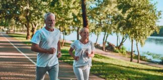Older couple jogging on a lakeside path
