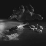 “At-Home” Habits That End Substance Addiction A hand reaching for pills next to a syringe and powder on a table
