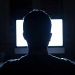 How Screen Time Reshapes Lifespan person silhouetted in front of a bright computer screen