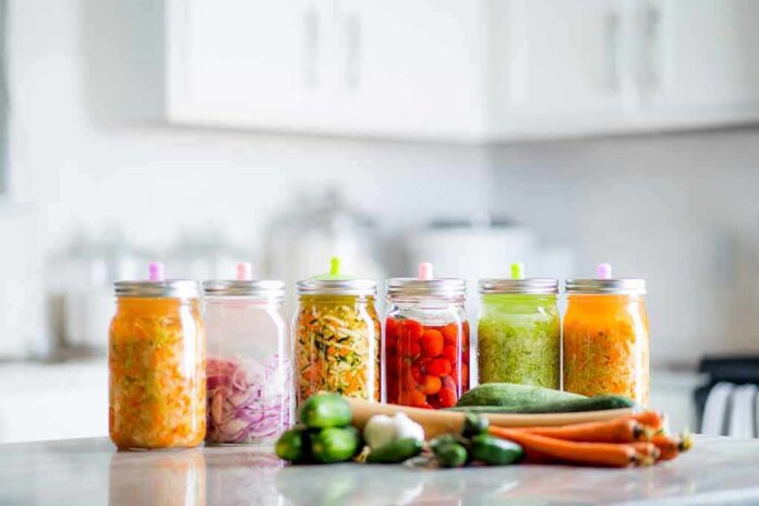 shutterstock_1138738340 Assorted pickled vegetables in jars on a kitchen counter