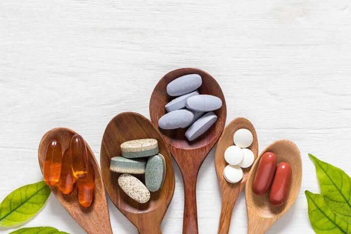 Assorted dietary supplements on wooden spoons