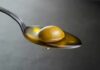 Olive Oil Gut Hack Goes Viral Green olive on a spoon with olive oil