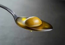 Olive Oil Gut Hack Goes Viral Green olive on a spoon with olive oil