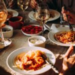 Pasta dinner with wine on a sunlit table