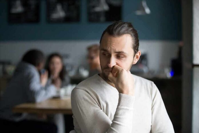 shutterstock_1194497179 man sitting alone in a cafe looking to the side