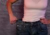 Simple Habits For Making A Healthy Weight-Loss Plan Easier To Follow person in white tank top showing loose jeans waistband