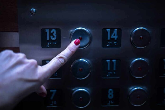 finger pressing elevator button for floor 13