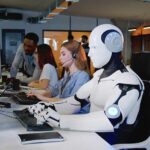 AI Empathy Exposed: The Compassion Illusion Robot and office workers at computers in a modern workspace