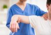 Train Hard, Skip Pain – The Spine Trick Physical therapist guiding a patient's arm during shoulder exercise