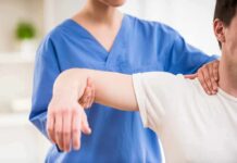 Train Hard, Skip Pain – The Spine Trick Physical therapist guiding a patient's arm during shoulder exercise
