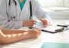 Doctor discusses medical notes with patient at a desk