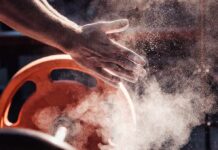 Farmers Walks: Muscle Building Game Changer Athlete’s chalked hands above an orange weight plate