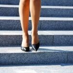 legs in black high heels walking down stone steps