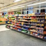 Dinner Staples Linked To Deadly Risks Supermarket aisle with shelves of snacks and candy