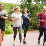 Group of four adults jogging on a park path