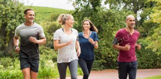 Group of four adults jogging on a park path